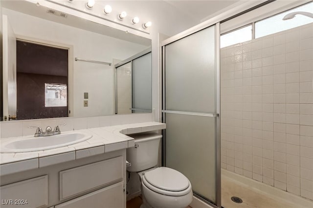 bathroom with toilet, vanity, and walk in shower