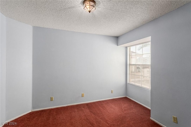 carpeted spare room with a textured ceiling