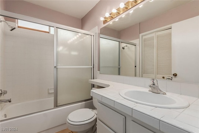 full bathroom with vanity, enclosed tub / shower combo, and toilet