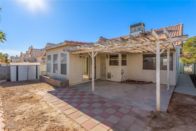 rear view of house featuring a pergola, central air condition unit, a patio, and a storage shed