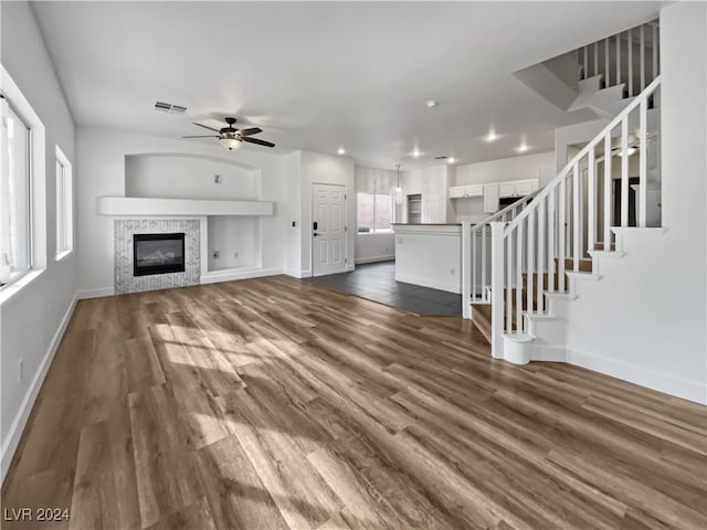 unfurnished living room with dark hardwood / wood-style floors and ceiling fan