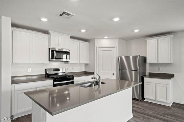 kitchen featuring a kitchen island with sink, white cabinets, sink, appliances with stainless steel finishes, and dark hardwood / wood-style flooring