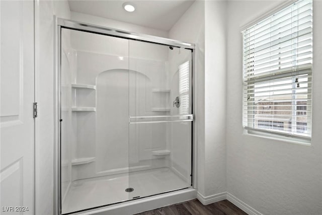 bathroom with wood-type flooring and a shower with door