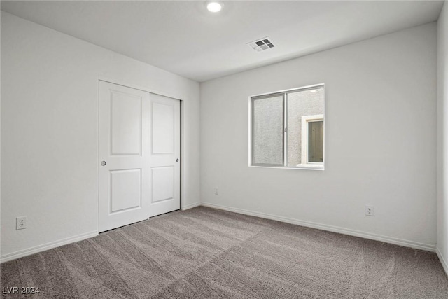 unfurnished bedroom featuring carpet floors and a closet