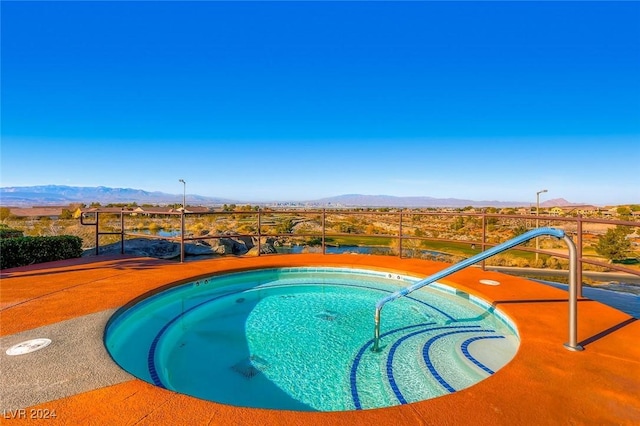 view of pool with a mountain view and an in ground hot tub