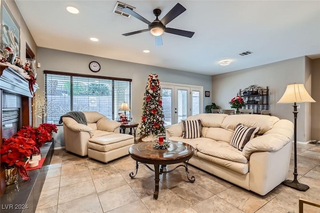 living room featuring ceiling fan, a wealth of natural light, and french doors