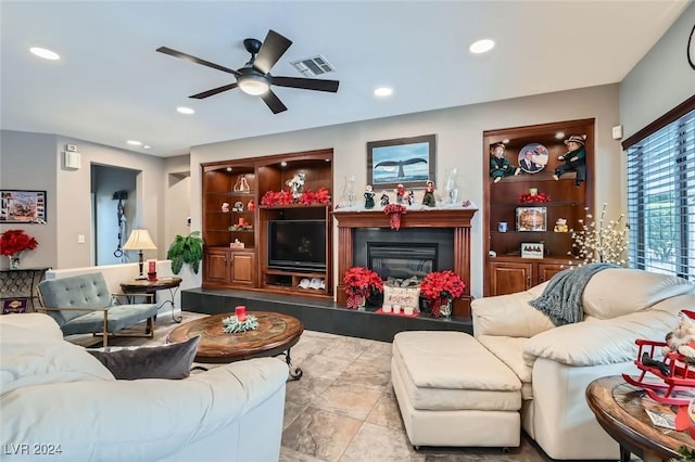 tiled living room featuring built in shelves and ceiling fan