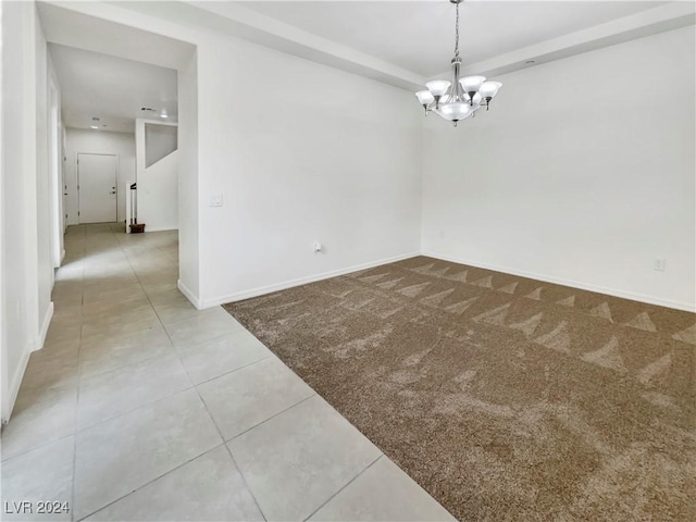 empty room with tile patterned floors and a notable chandelier