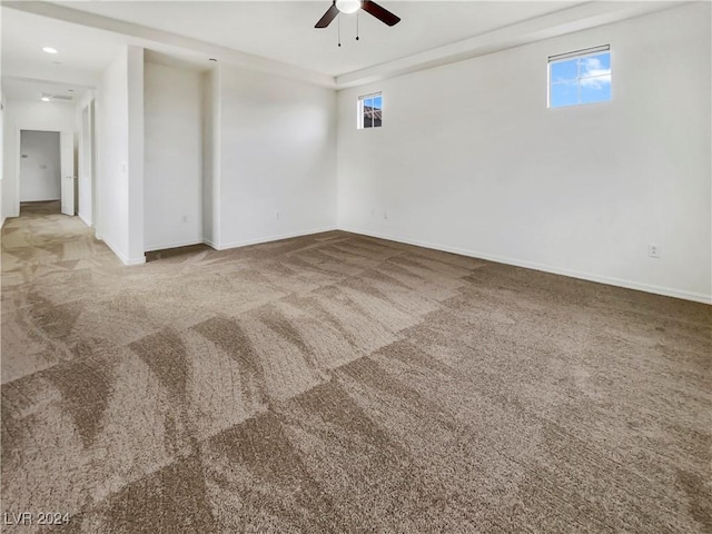 carpeted empty room featuring a wealth of natural light and ceiling fan