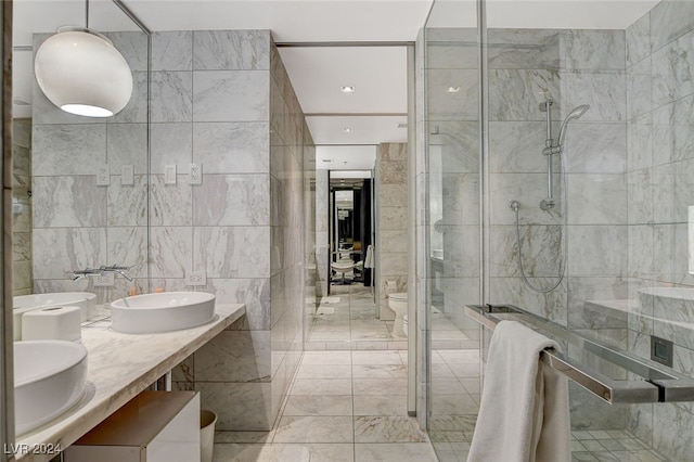 bathroom featuring vanity, toilet, tile walls, and walk in shower