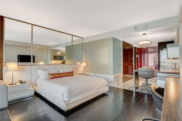 bedroom with wood-type flooring, sink, and a closet