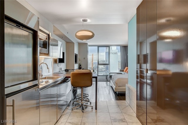 kitchen featuring stainless steel microwave and a wall of windows