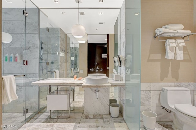 bathroom featuring walk in shower, toilet, tile walls, and sink