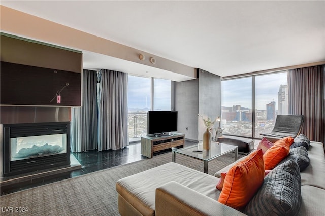 living room with a multi sided fireplace, floor to ceiling windows, and a healthy amount of sunlight