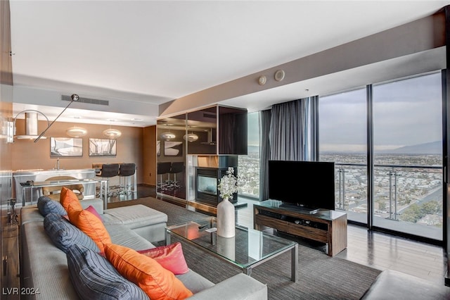 living room featuring a multi sided fireplace and floor to ceiling windows