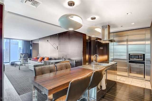 dining area with sink, hardwood / wood-style floors, and a wall of windows