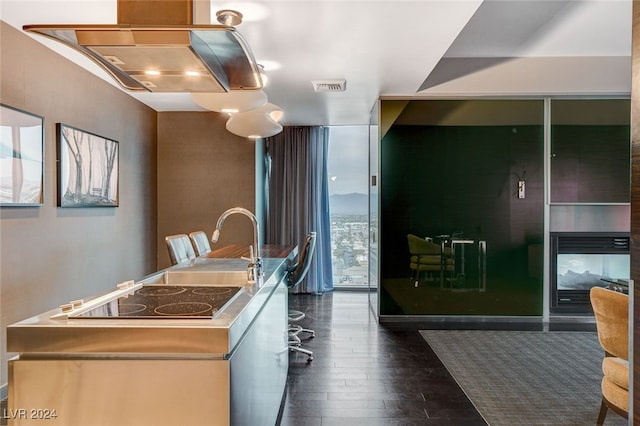 kitchen with expansive windows, dark wood-type flooring, and electric stovetop