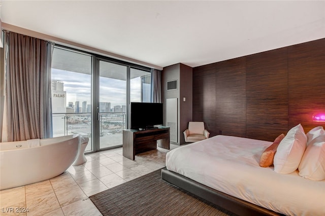 tiled bedroom with expansive windows, access to exterior, and wooden walls