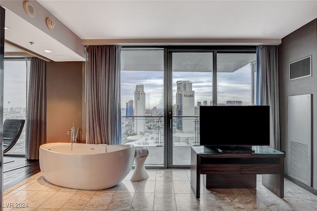 bathroom featuring expansive windows and a tub