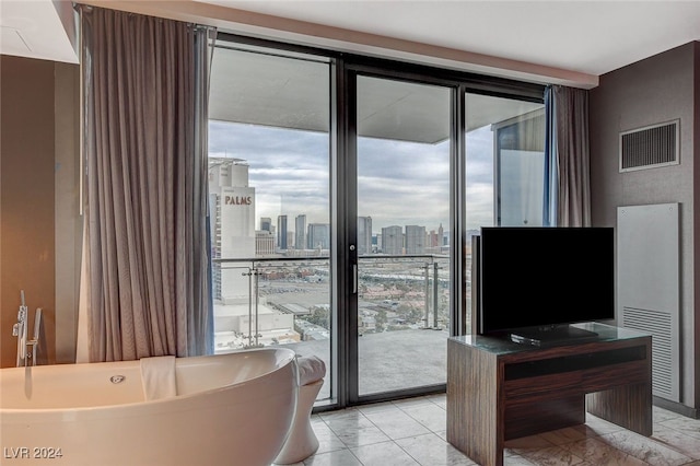 living room with a healthy amount of sunlight, light tile patterned flooring, and floor to ceiling windows