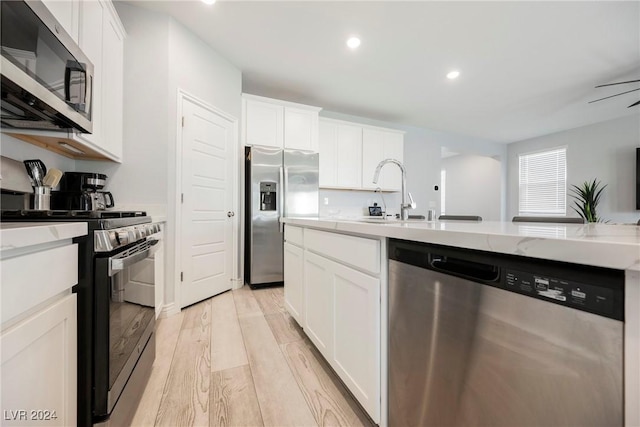 kitchen featuring white cabinets, light wood-type flooring, and appliances with stainless steel finishes