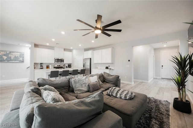 living room featuring light wood-type flooring and ceiling fan