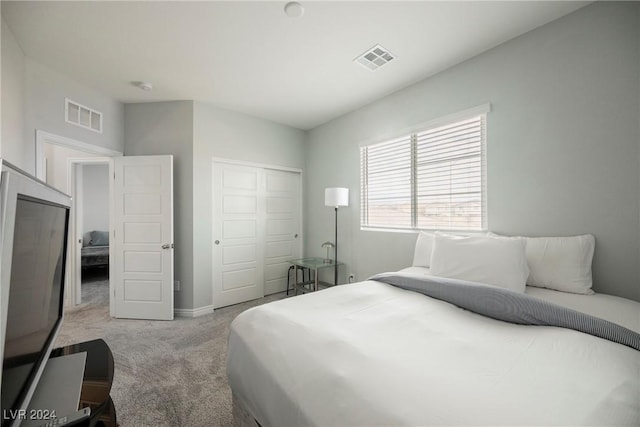 bedroom featuring a closet and light carpet