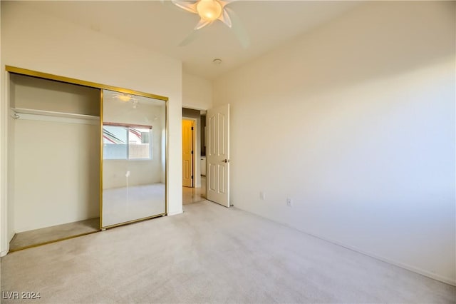 unfurnished bedroom featuring light carpet, ceiling fan, and a closet