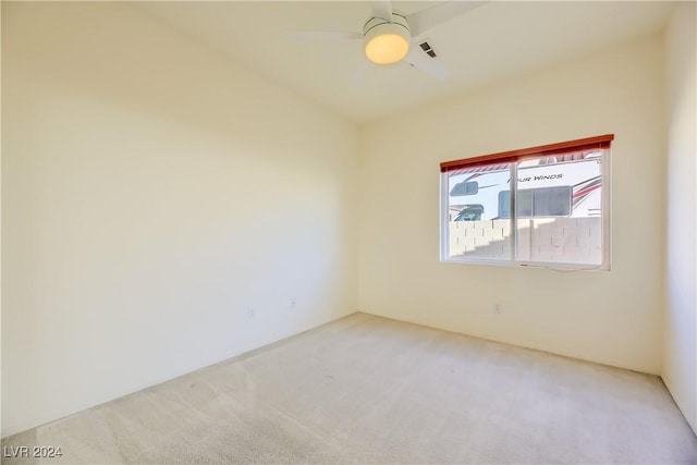 carpeted spare room with ceiling fan