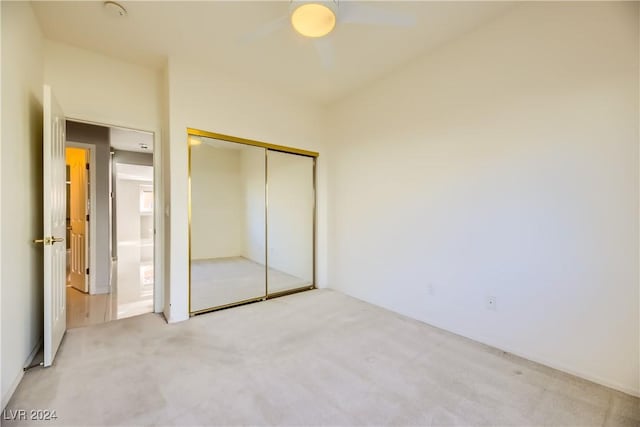 unfurnished bedroom with a closet, ceiling fan, and light colored carpet