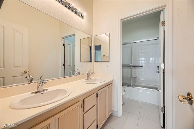 full bathroom featuring shower / bath combination with glass door, vanity, toilet, and tile patterned floors