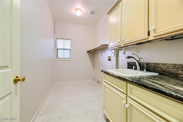 washroom with washer hookup, cabinets, light tile patterned floors, and sink