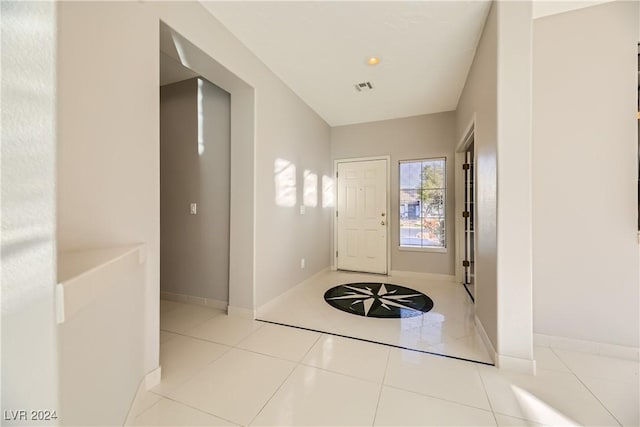 foyer entrance featuring baseboards, visible vents, and tile patterned floors