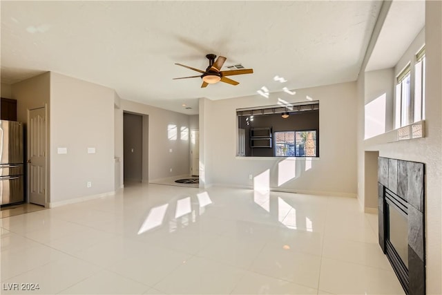 unfurnished living room featuring light tile patterned floors and ceiling fan