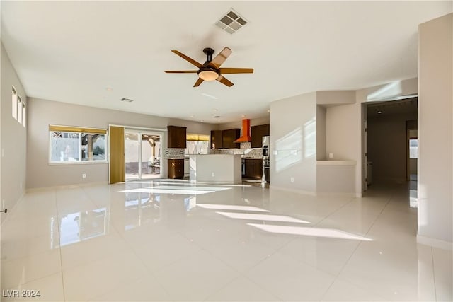 unfurnished living room featuring ceiling fan and light tile patterned floors