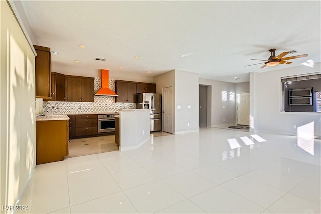 kitchen with stainless steel appliances, sink, light tile patterned floors, wall chimney range hood, and decorative backsplash