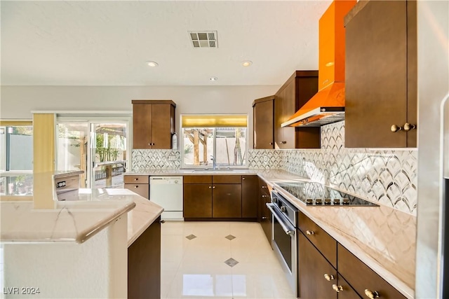 kitchen featuring white dishwasher, black electric stovetop, wall chimney range hood, decorative backsplash, and sink