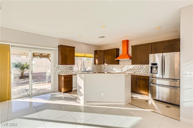 kitchen with custom range hood, stainless steel refrigerator with ice dispenser, decorative backsplash, light tile patterned floors, and white dishwasher