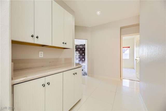 kitchen with light tile patterned flooring and white cabinets