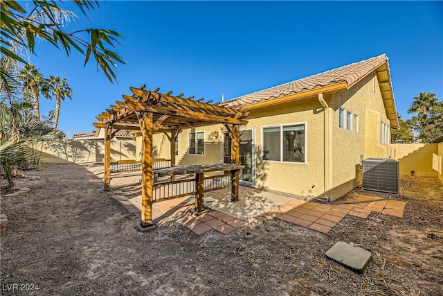 rear view of house featuring central AC, a pergola, and a patio area