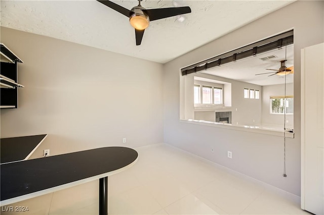 unfurnished office with baseboards, visible vents, and a ceiling fan