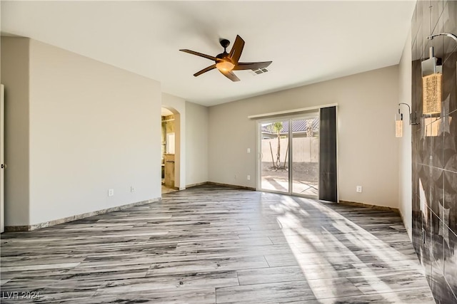 unfurnished room with light wood-type flooring and ceiling fan