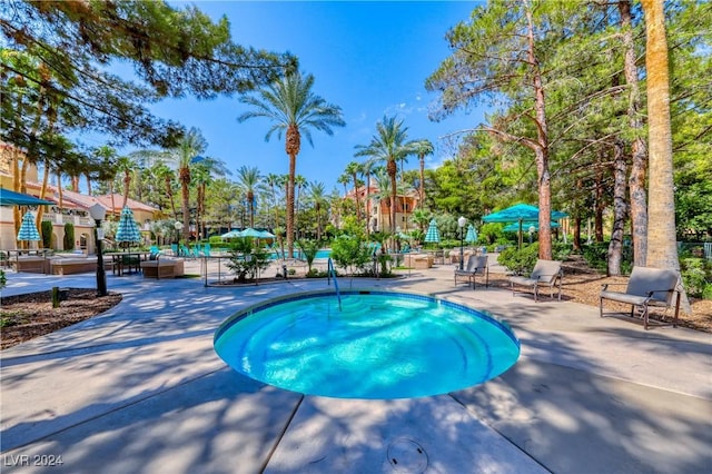 view of swimming pool featuring an in ground hot tub and a patio