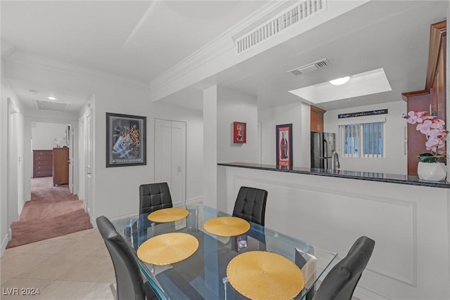 dining space featuring crown molding, sink, and light tile patterned floors