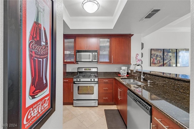 kitchen featuring light tile patterned flooring, stainless steel appliances, dark stone countertops, and sink