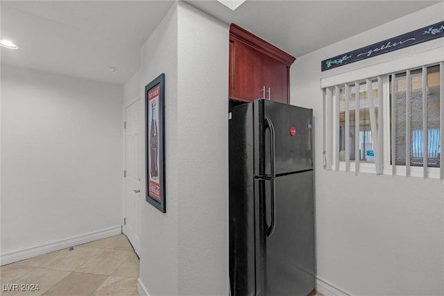 kitchen with black refrigerator and light tile patterned flooring