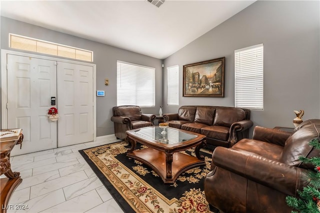 living room featuring vaulted ceiling and a healthy amount of sunlight