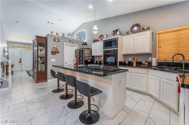 kitchen with sink, gas stovetop, stainless steel fridge, oven, and an island with sink