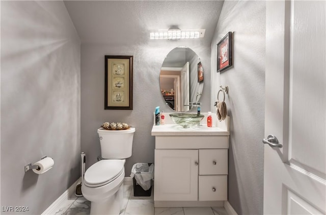 bathroom with vanity, toilet, and a textured ceiling