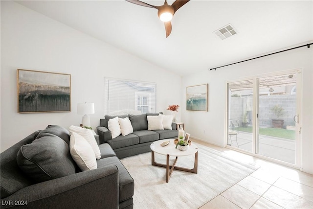 tiled living room with lofted ceiling, ceiling fan, and a healthy amount of sunlight